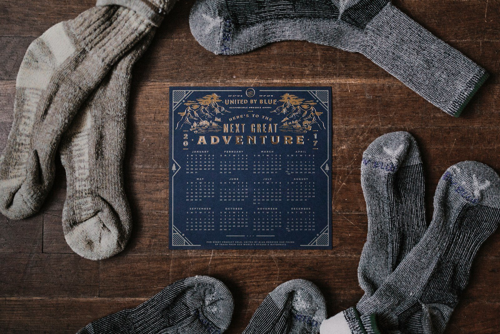 Several pairs of grey wool hiking socks laid out on a wooden table.