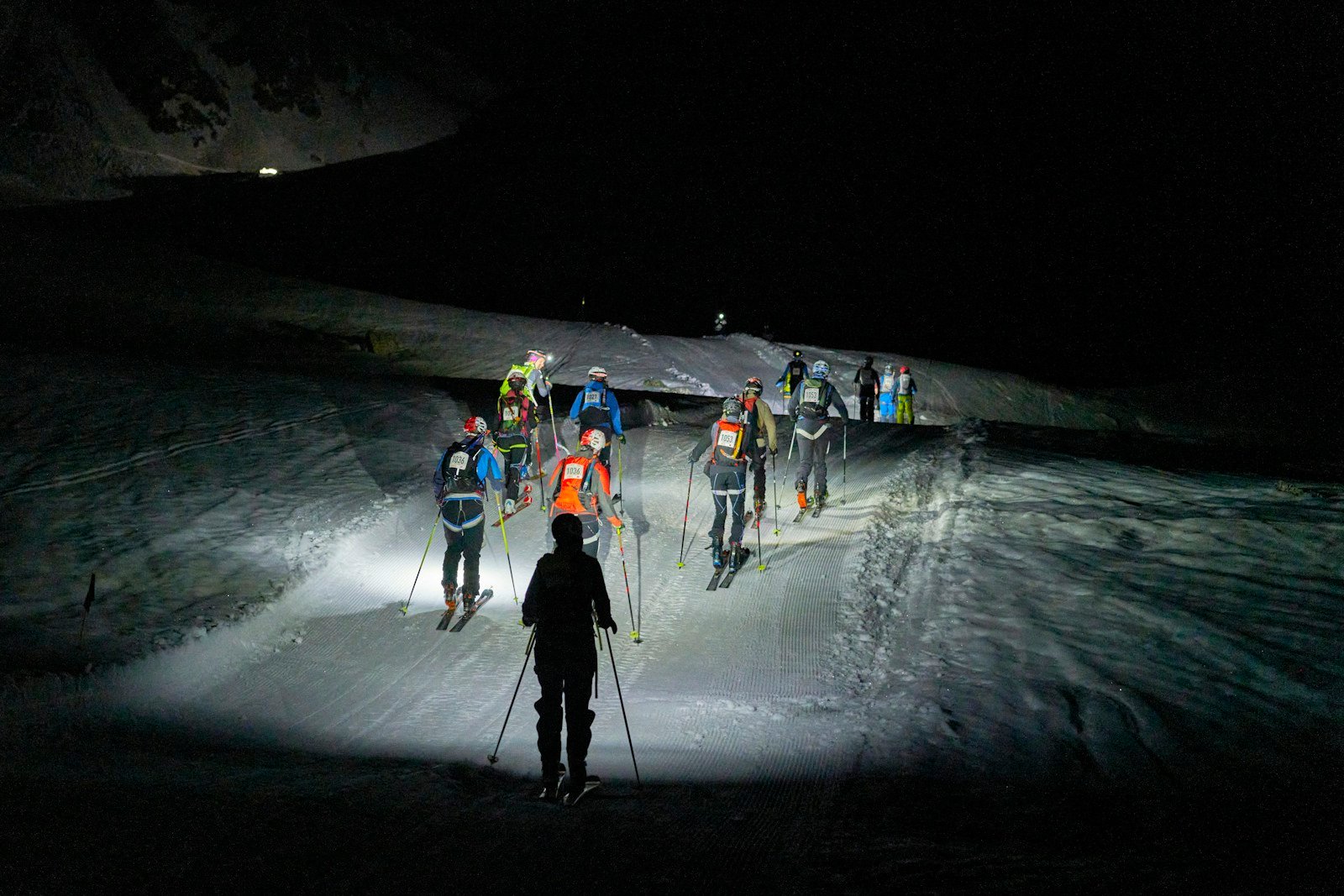 A climber's headlamp on a night ascent at altitude.